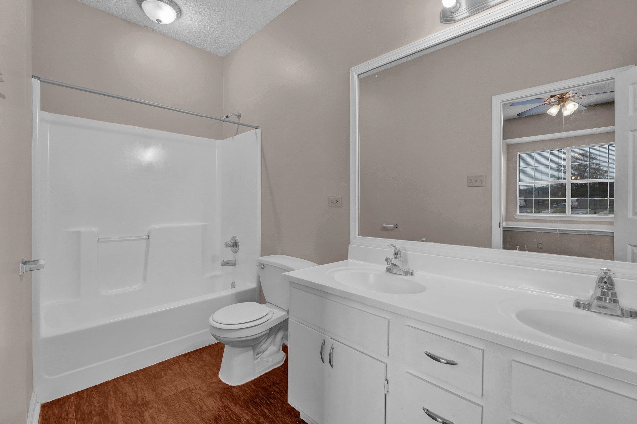 6309 Ragan Farm Drive Memphis, TN 38141 - Photo 5 of 25 Full bathroom featuring a textured ceiling, shower / bath combination, hardwood / wood-style flooring, toilet, and ceiling fan