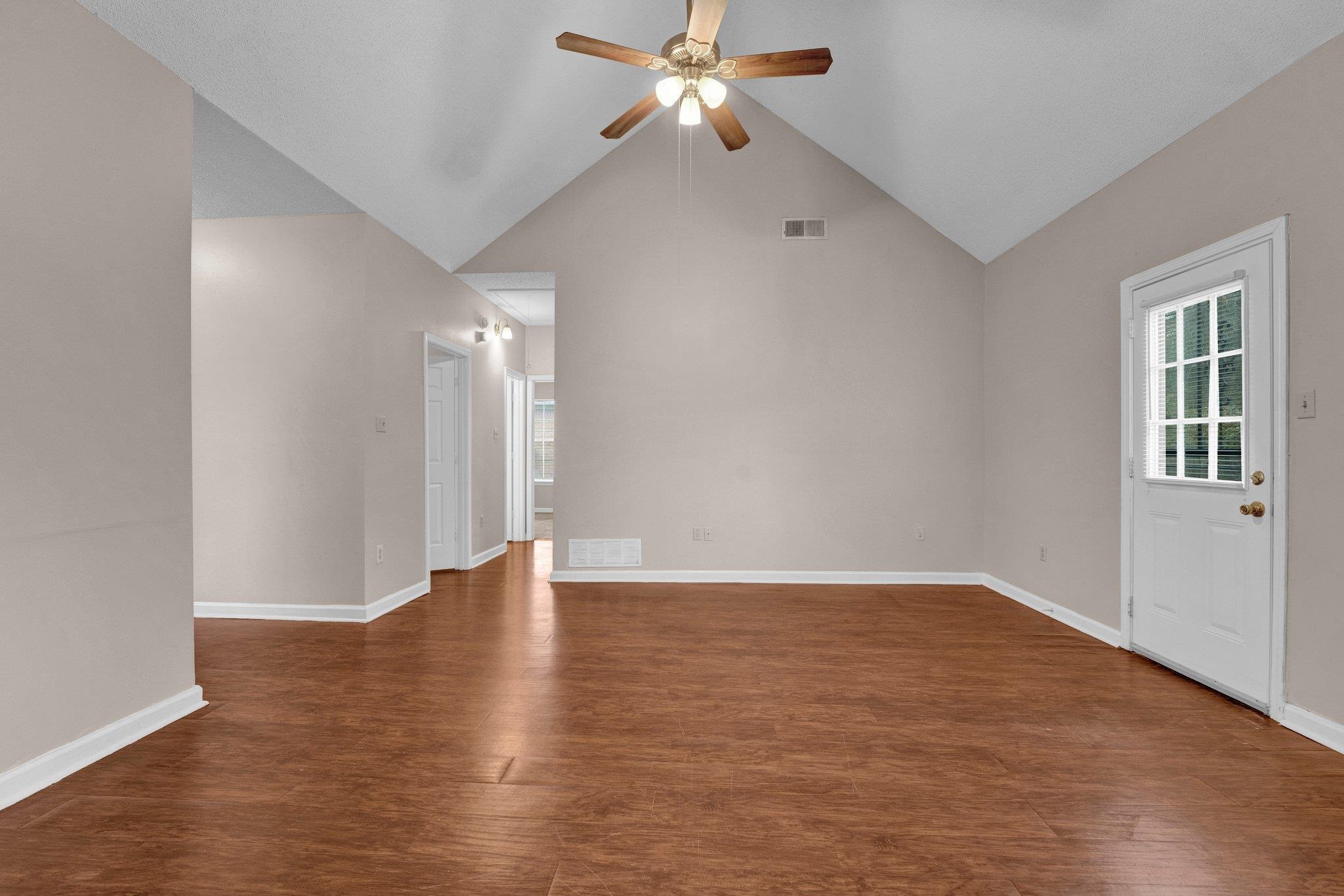 6309 Ragan Farm Drive Memphis, TN 38141 - Photo 10 of 25 Unfurnished living room featuring ceiling fan, dark hardwood / wood-style floors, and high vaulted ceiling