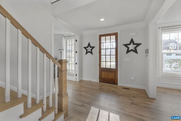 a view of an entryway with wooden floor and livingroom view