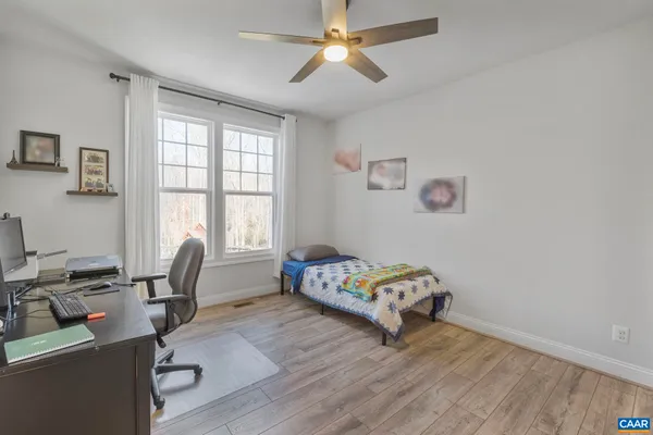 a spacious bedroom with a bed a table and windows
