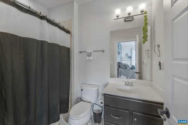 a bathroom with a sink a toilet and shower curtain