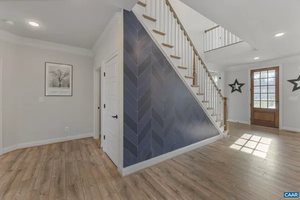 a view of entryway and hall with wooden floor