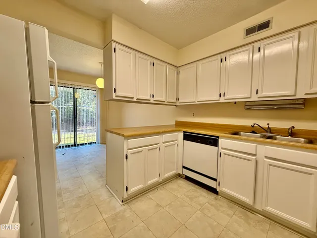 a kitchen with white cabinets and white appliances