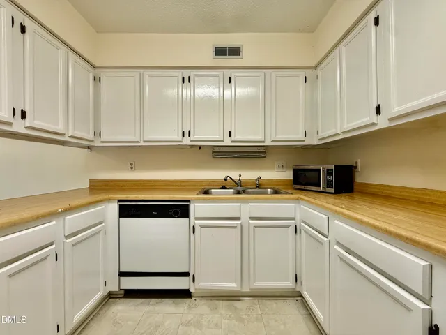 a kitchen with white cabinets and white appliances