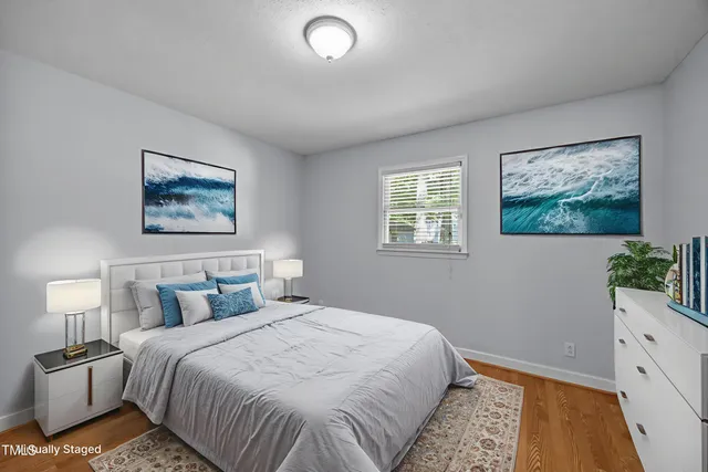a bedroom with a large bed and a potted plant