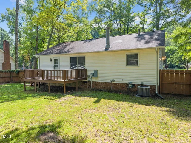 a view of a house with a yard and a wooden deck