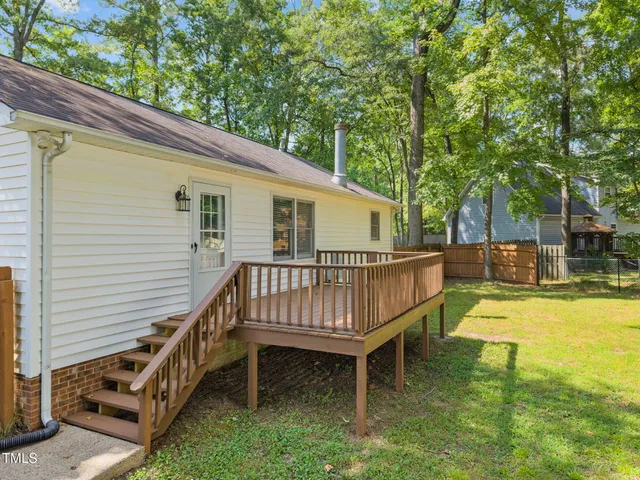 a view of backyard with deck and a garden