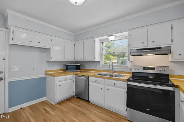 a kitchen with granite countertop white cabinets and white appliances