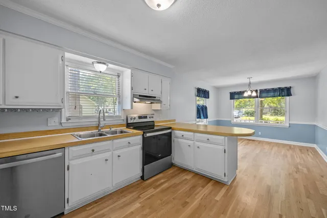 a kitchen with a sink a window and cabinets