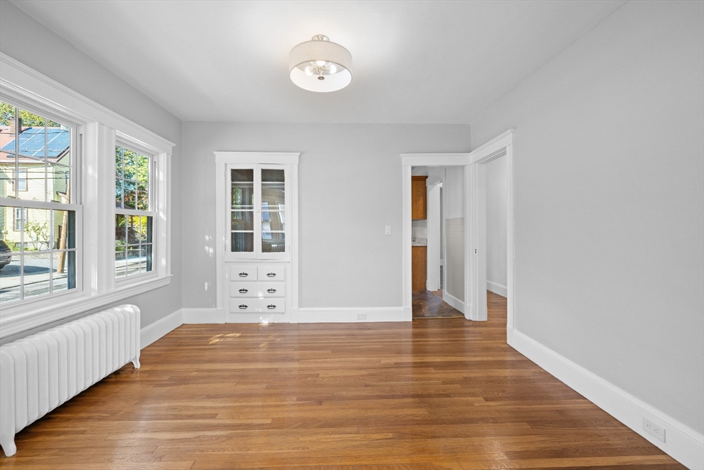 19 Alabama Street, Unit 1 Boston, MA 02126 - Photo 10 of 16 an empty room with wooden floor and windows