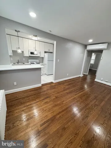 a view of kitchen view with wooden floor and cabinets