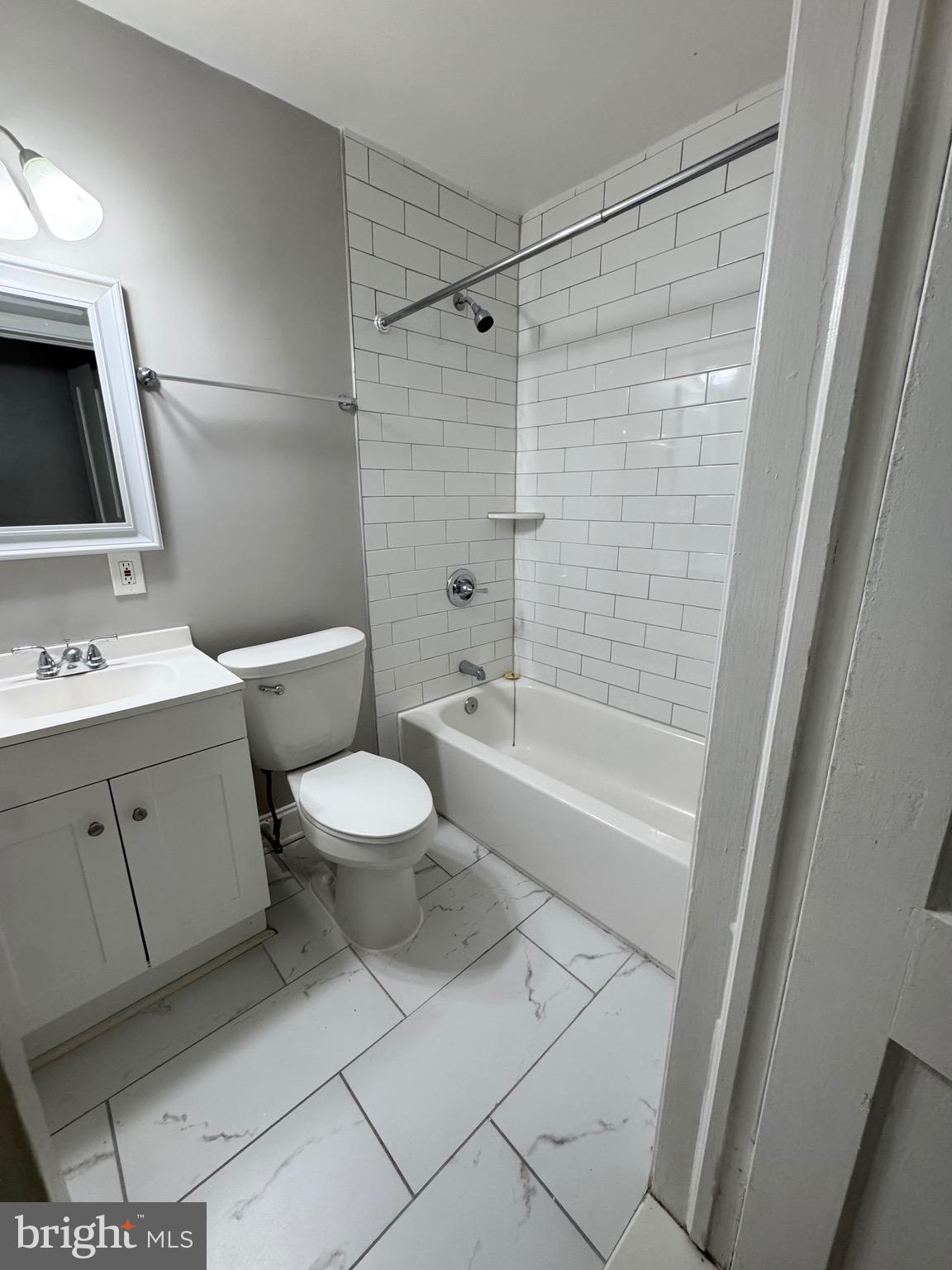 1104 Meridene Drive, Unit 1 Baltimore, MD 21239 - Photo 5 of 7 a bathroom with a toilet sink and shower