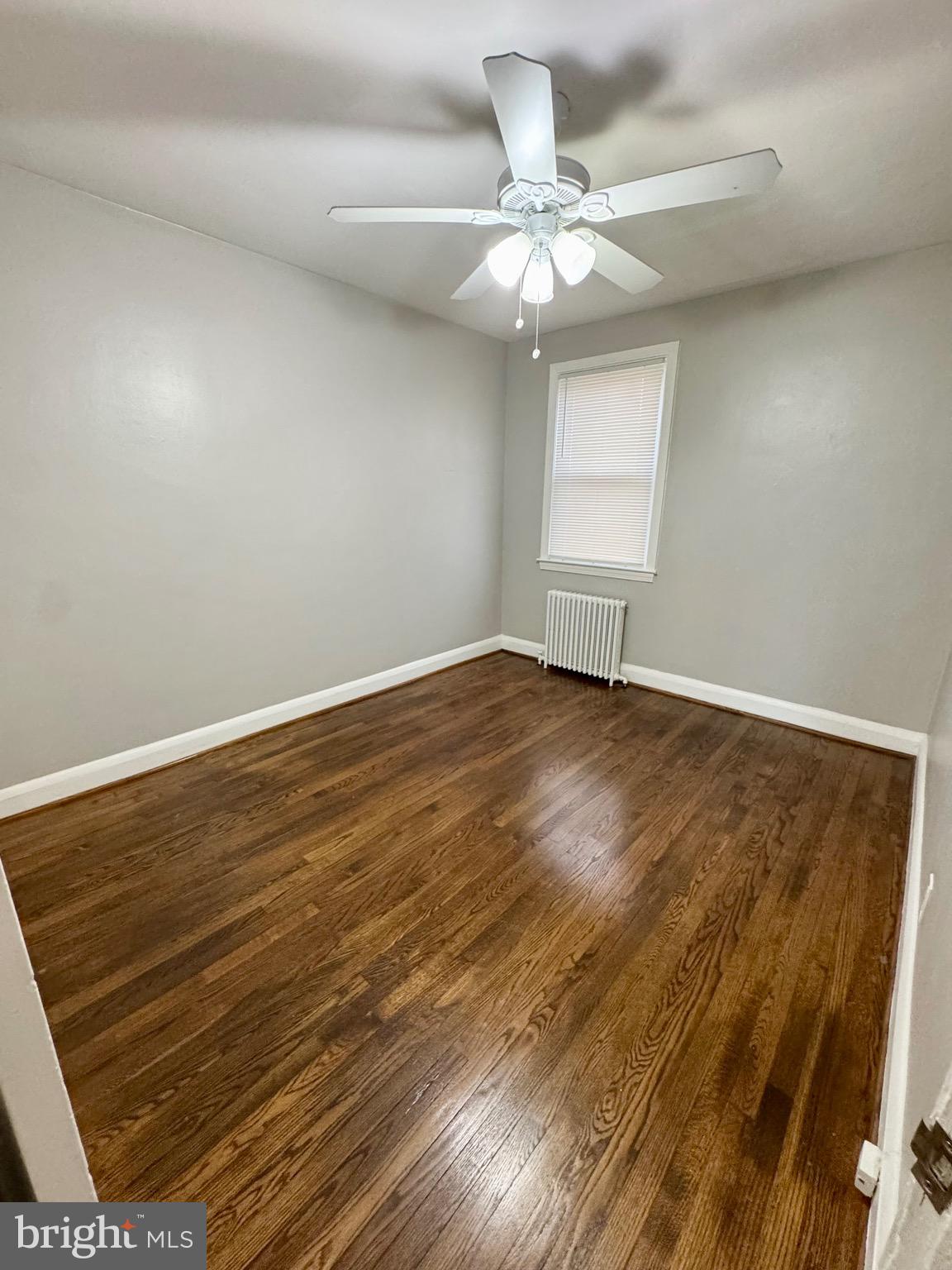 1104 Meridene Drive, Unit 1 Baltimore, MD 21239 - Photo 7 of 7 an empty room with wooden floor fan and windows