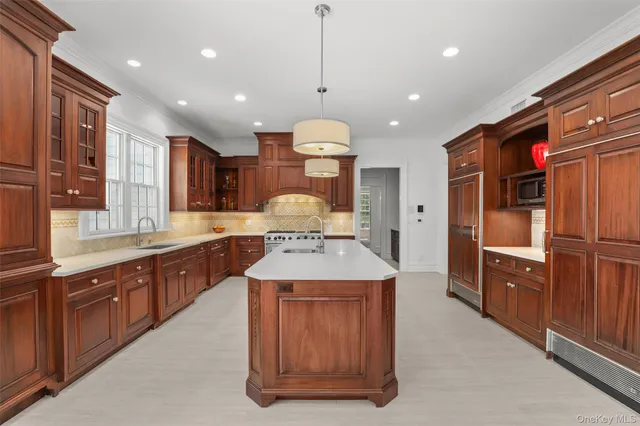 a large kitchen with stainless steel appliances granite countertop a stove a sink and a refrigerator