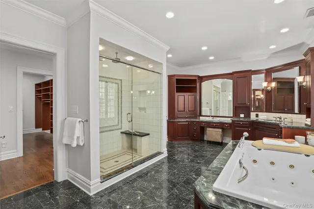 a bathroom with a tub a double vanity sink a mirror and shower