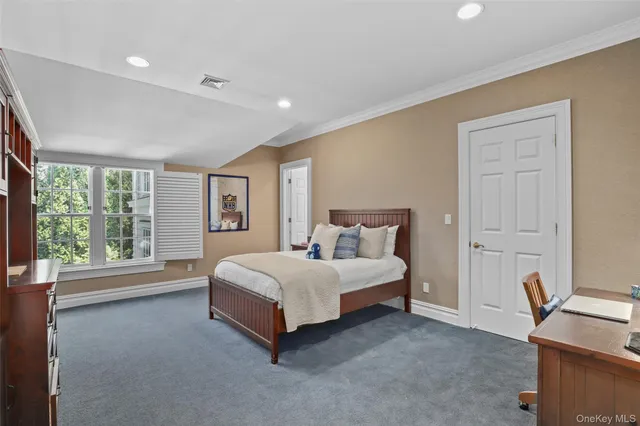 a spacious bedroom with a bed and a window