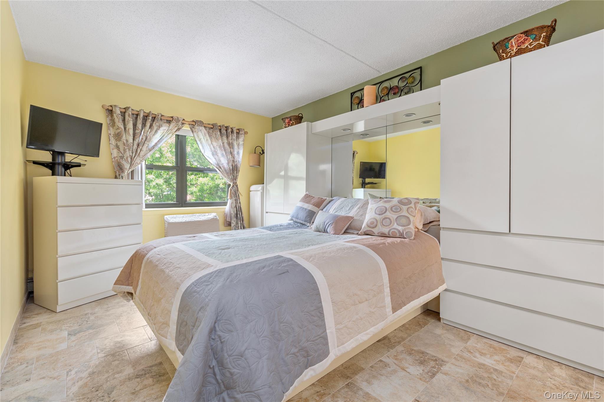 71-28 Sutton Place, Unit 3 Queens, NY 11365 - Photo 13 of 23 Bedroom with stone finish flooring and a textured ceiling