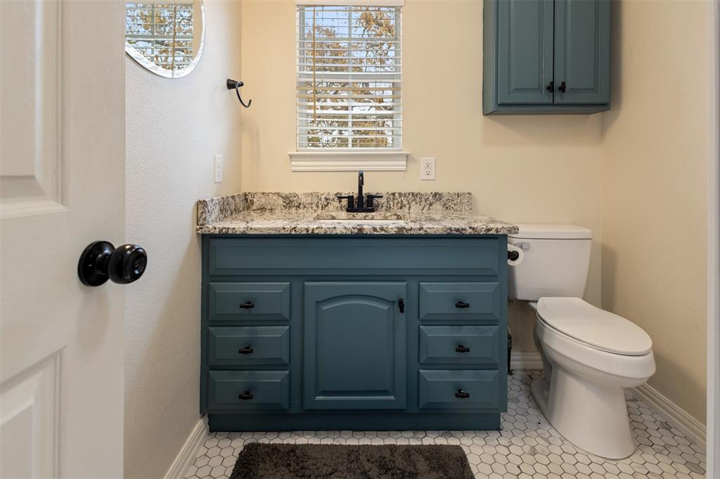106 White Oak Mabank, TX 75156 - Photo 20 of 32 a bathroom with a toilet a sink and a window