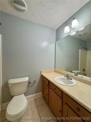 a bathroom with a toilet sink vanity granite and mirror