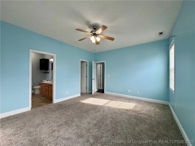a view of a big room with chandelier fan and windows