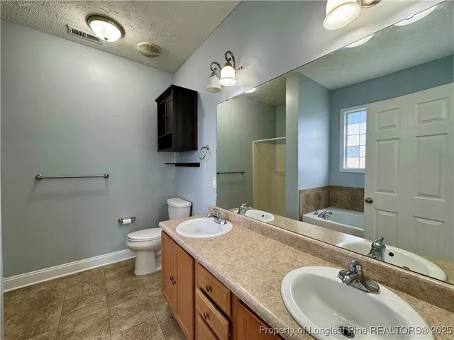 a bathroom with a granite countertop sink a large mirror and a toilet