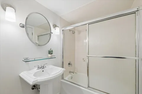 a bathroom with a sink shower and a mirror
