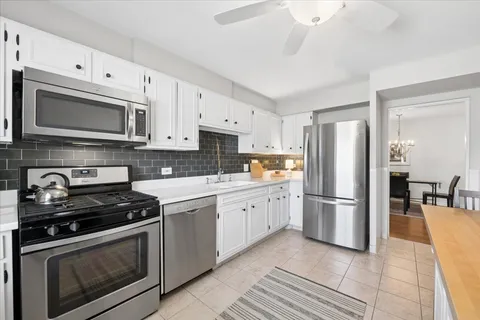 a kitchen with cabinets stainless steel appliances and a counter space