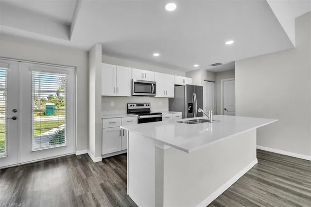 a view of kitchen with sink microwave and refrigerator