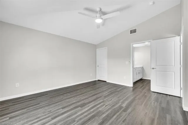 an empty room with wooden floor and ceiling fan