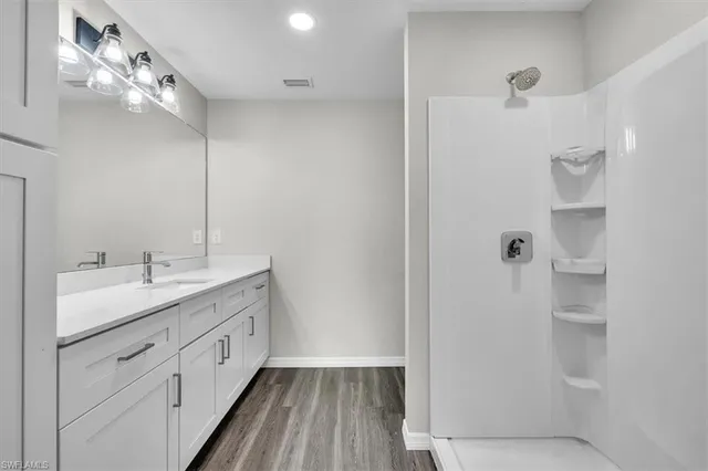 a bathroom with a double vanity sink a mirror and shower