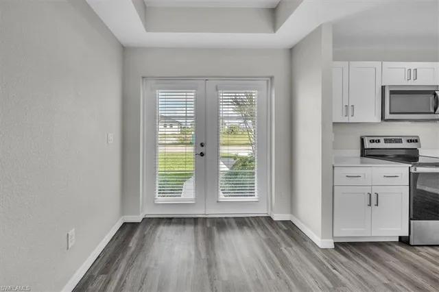 a view of kitchen and wooden floor electronic appliances and window