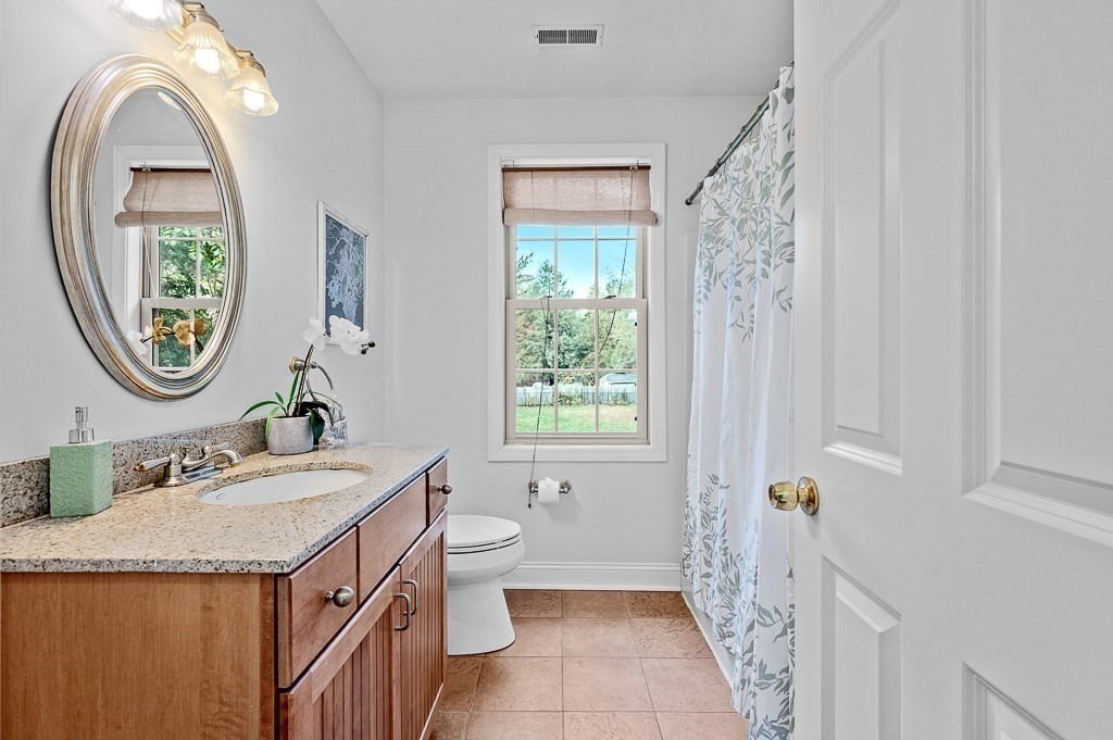 3 Carter Way Worcester, MA 01609 - Photo 28 of 41 a bathroom with a granite countertop toilet a mirror and a sink