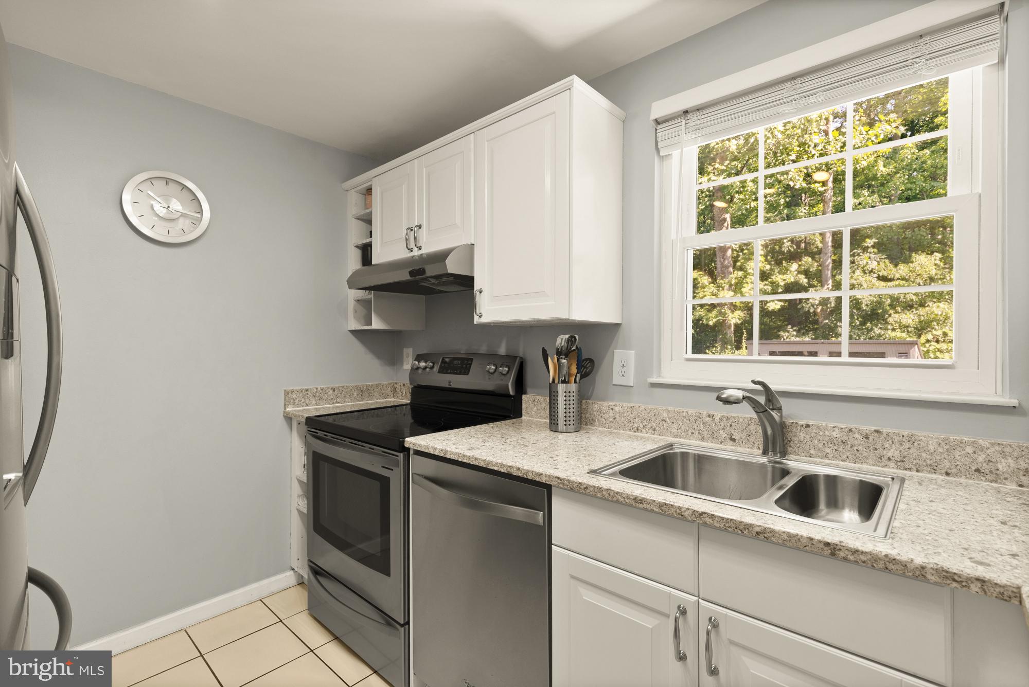 8100 Loving Forest Court Springfield, VA 22153 - Photo 12 of 33 a kitchen with granite countertop a sink stainless steel appliances and a window