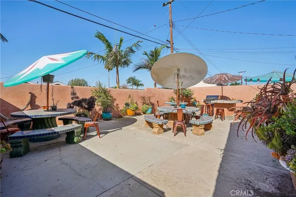 a view of patio with chairs and table under an umbrella