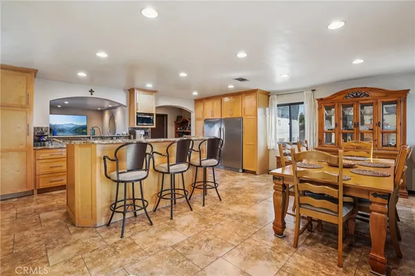 a living room with stainless steel appliances furniture a dining table and chairs