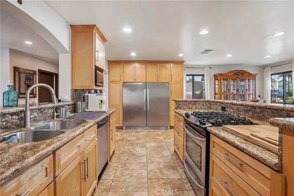 a kitchen with stainless steel appliances granite countertop a stove a sink and a refrigerator