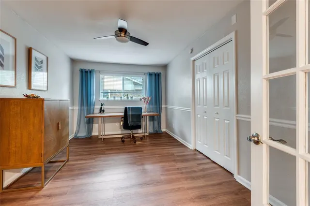 a view of a livingroom with wooden floor and a workspace