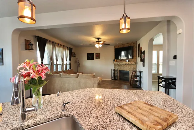 a view of a dining room and livingroom with furniture wooden floor a chandelier