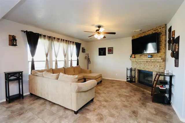a living room with furniture a fireplace and a flat screen tv