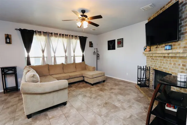 a living room with furniture a flat screen tv and a fireplace