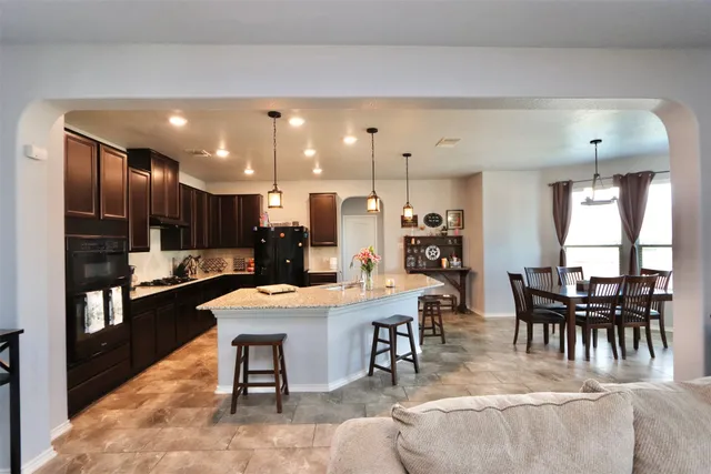 a large kitchen with a table and chairs