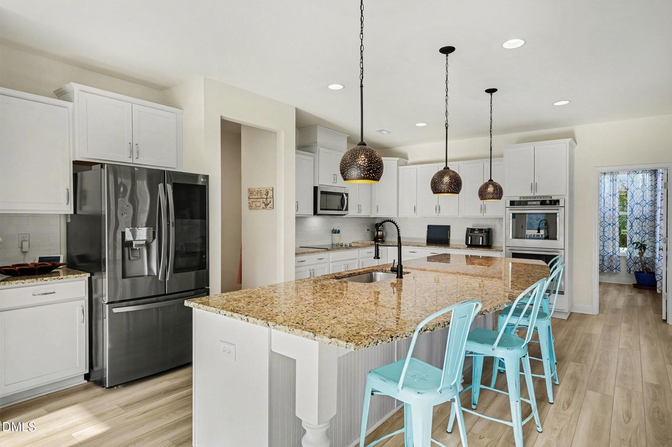 185 Twilight Trail Willow Spring, NC 27592 - Photo 15 of 42 a kitchen with stainless steel appliances granite countertop a stove a refrigerator a oven a kitchen island a table and chairs