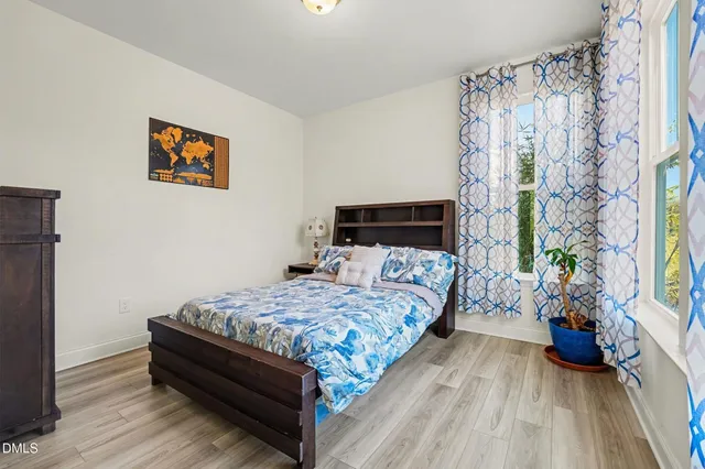 a bedroom with a bed and wooden floor