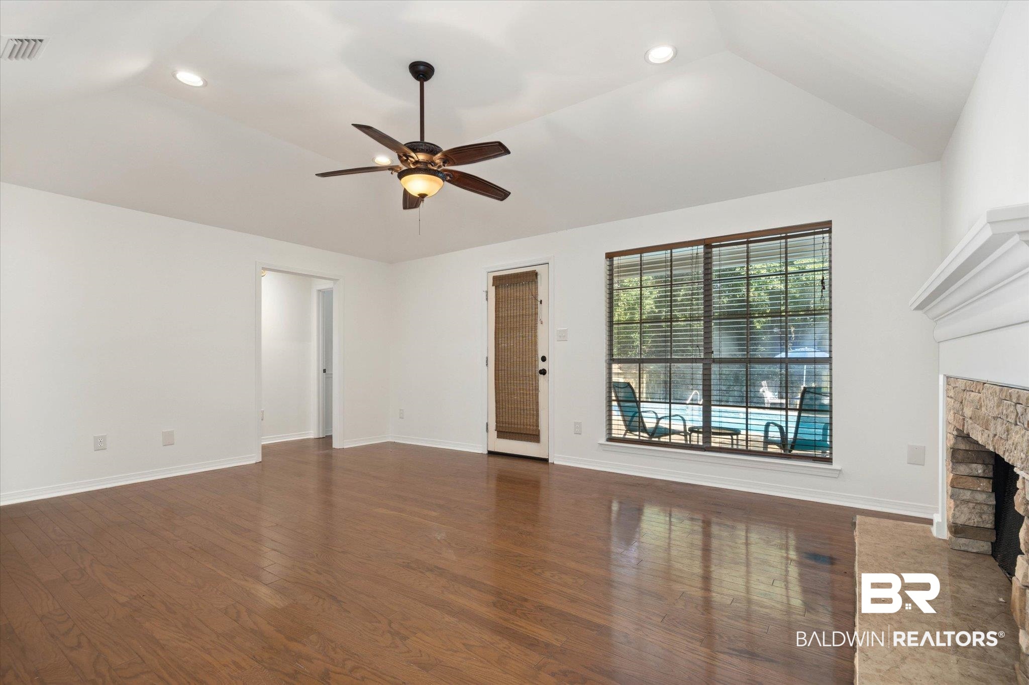 3032 Autumn Ridge Drive West Mobile, AL 36695 - Photo 9 of 20 Unfurnished living room with ceiling fan, wood finished floors, a fireplace, recessed lighting, and vaulted ceiling
