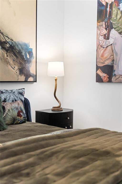 567 Ponce De Leon Avenue Northeast, Unit 419 Atlanta, GA 30308 - Photo 18 of 34 a bedroom with a bed and lamp on dresser