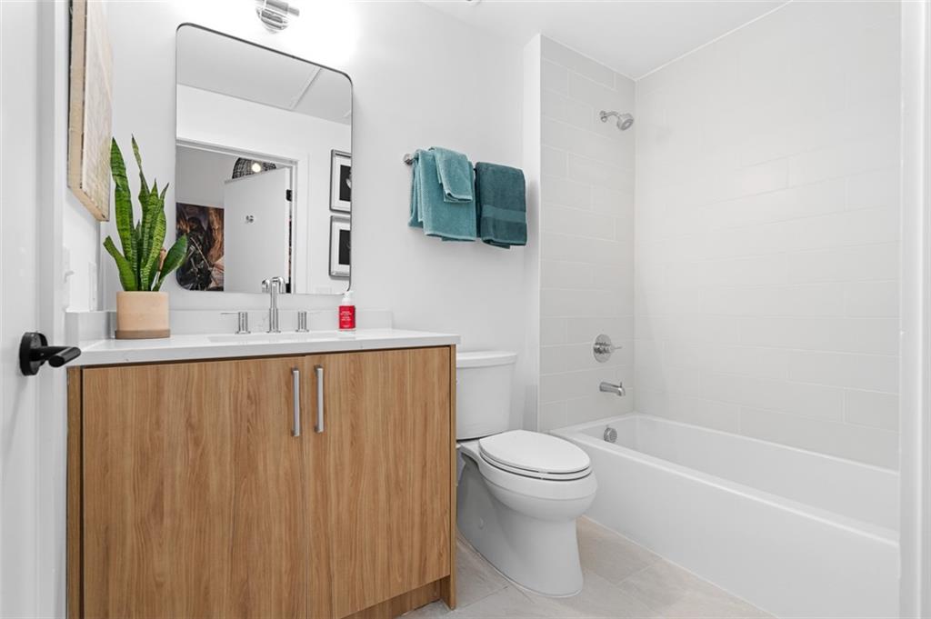 567 Ponce De Leon Avenue Northeast, Unit 419 Atlanta, GA 30308 - Photo 20 of 34 a bathroom with a sink toilet and mirror