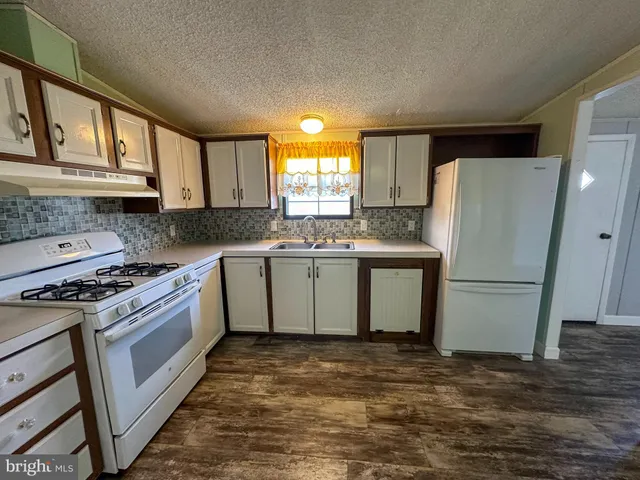 a kitchen with a stove a sink and a refrigerator