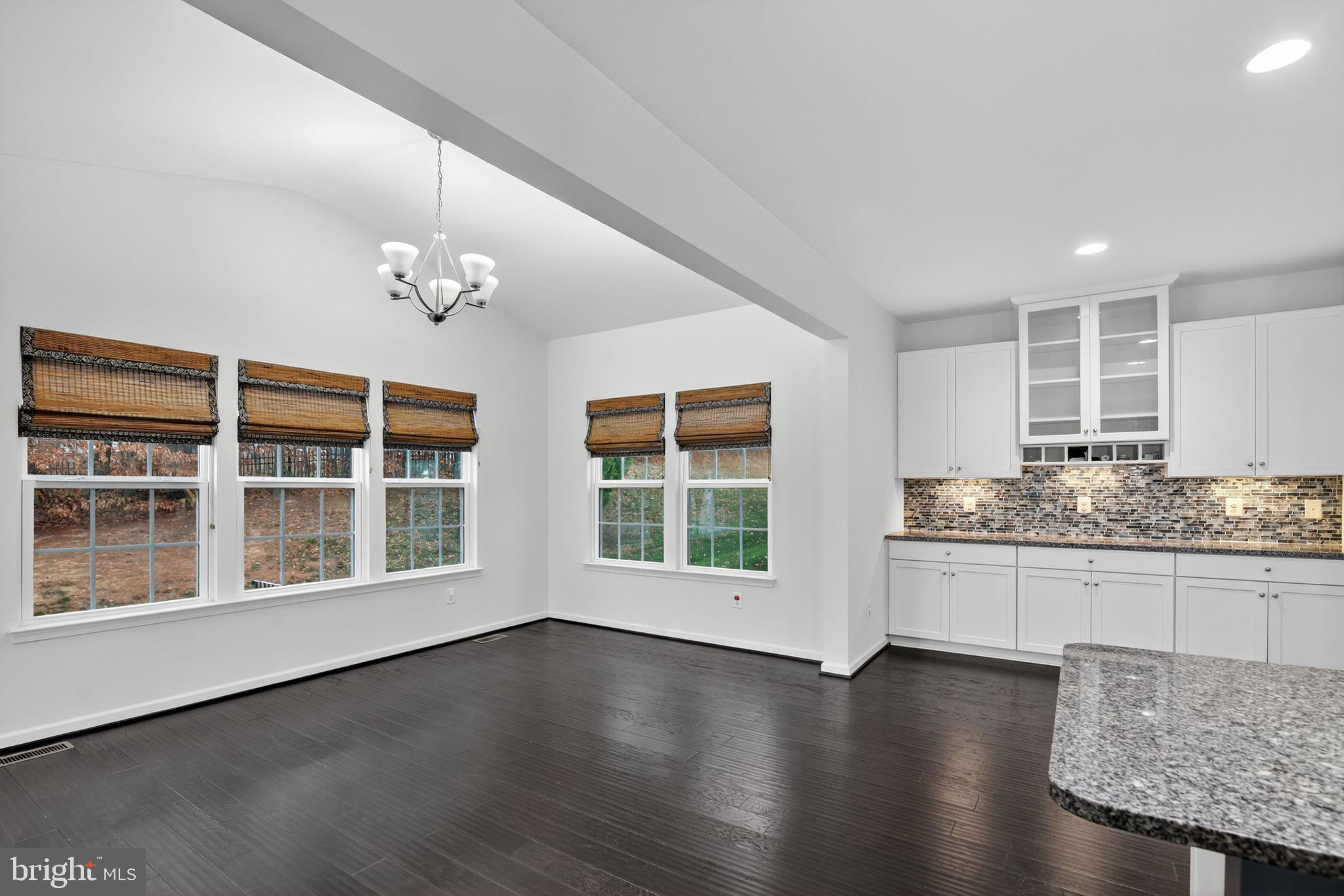 4401 Weejun Loop Woodbridge, VA 22192 - Photo 12 of 35 a view of an empty room with wooden floor and a kitchen