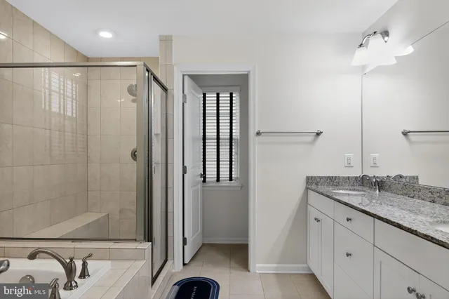 a bathroom with a granite countertop sink a mirror and shower