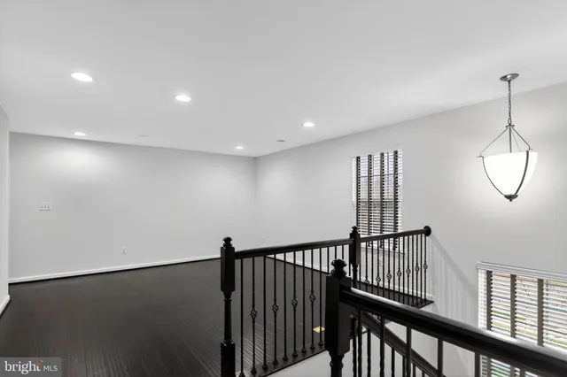 a view of a hallway with wooden floor and windows